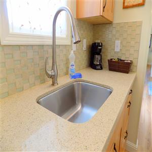 Large stainless steel sink with pull-out faucet.