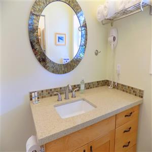 Well lit sink and vanity w/ wall mount hairdryer.