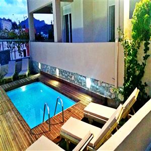 Wonderful swimming pool view with wooden chairs.