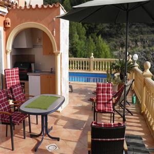 Outdoor kitchen with a barbecue, fridge and sink.